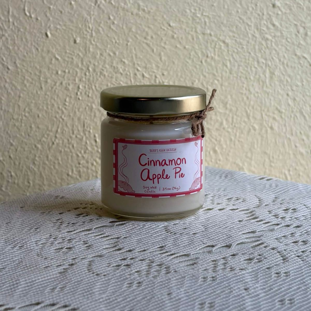 Cinnamon Apple Pie 3.4oz candle on a lace table cloth