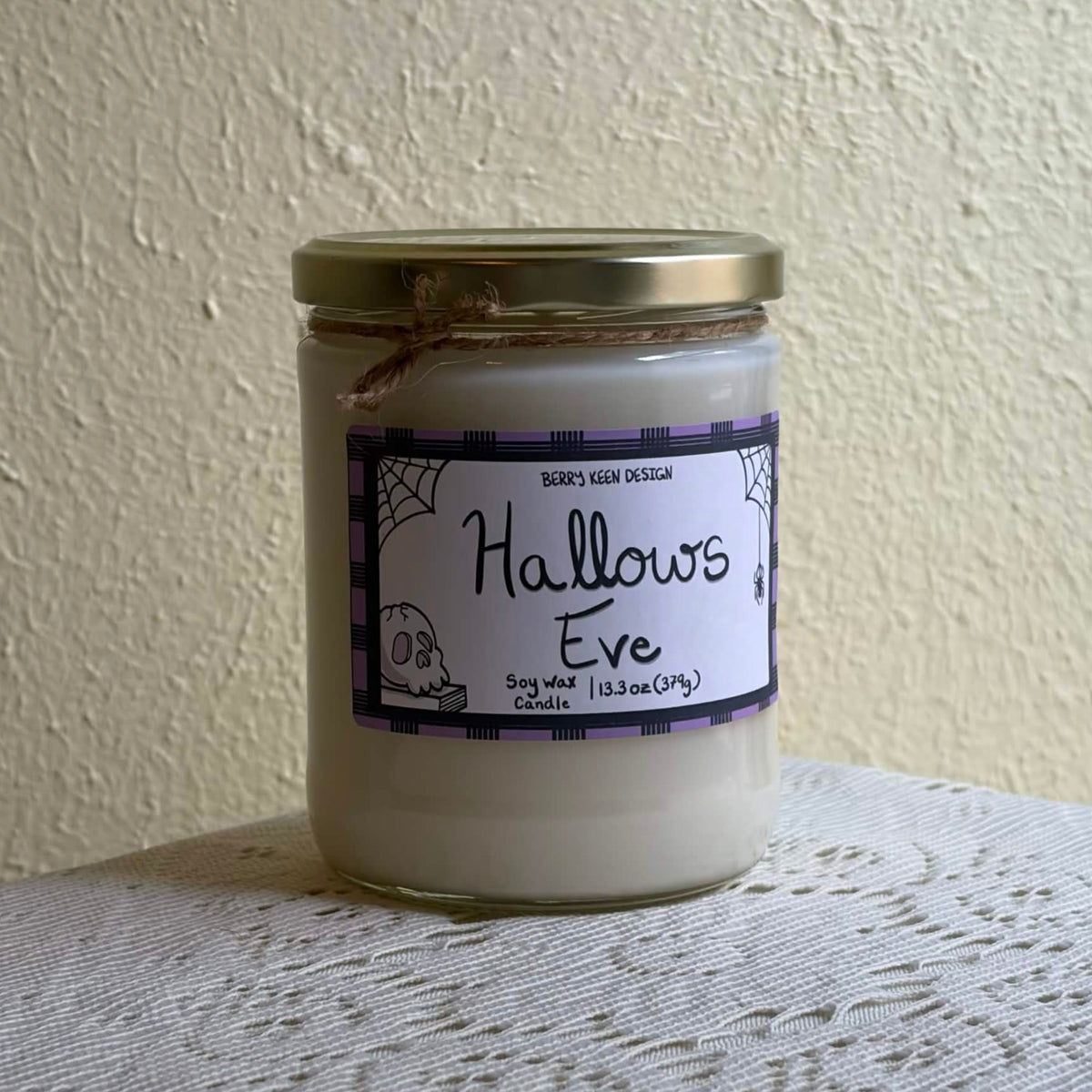 Hallows Eve 13.3oz candle on a lace table cloth