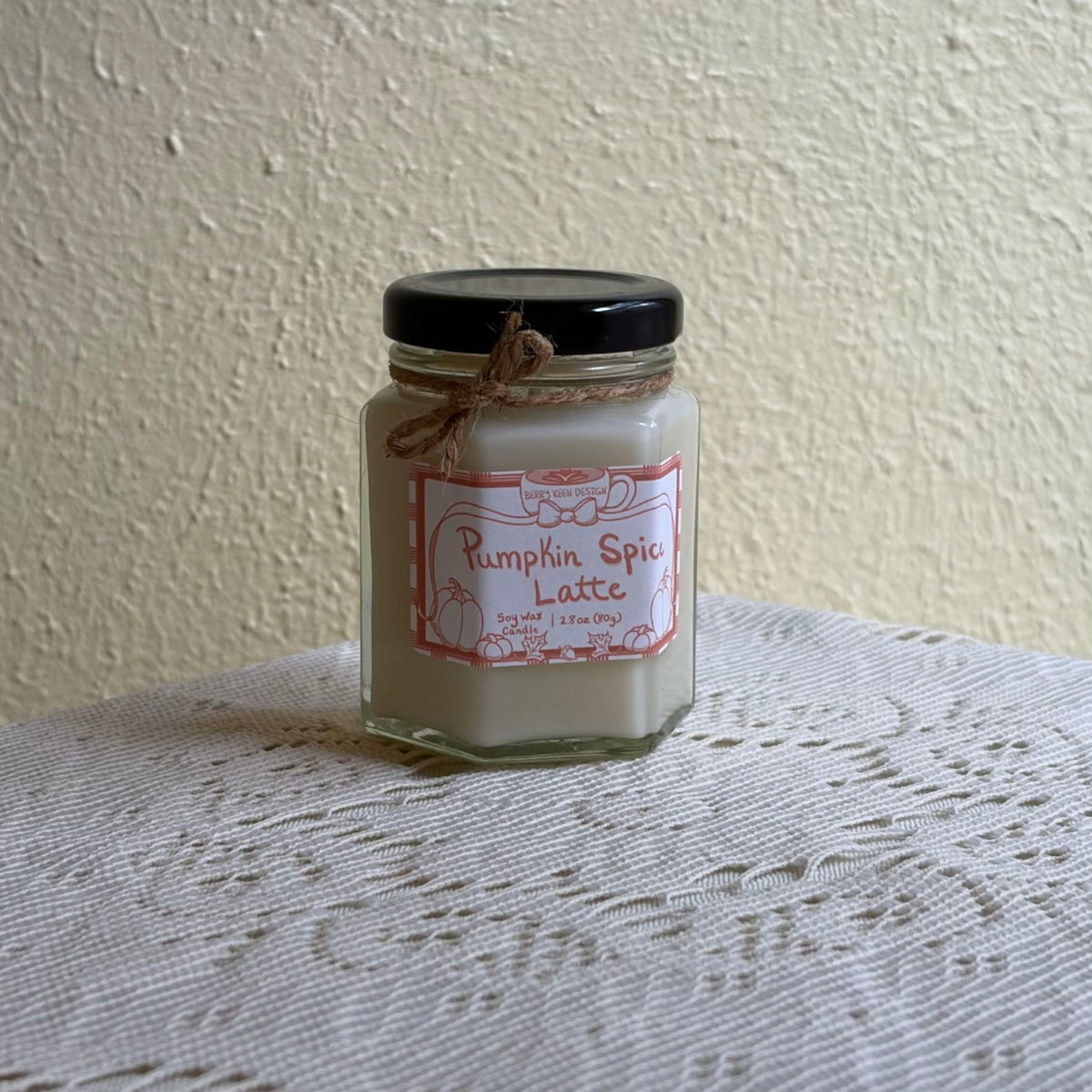 Pumpkin spice candle on a lace tablecloth
