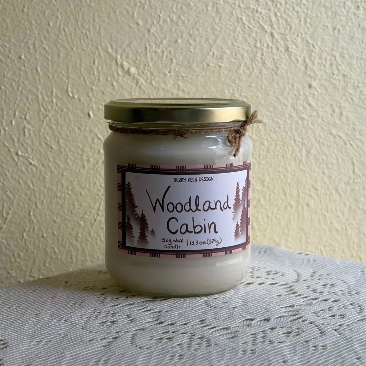 Woodland Cabin candle on a lace table cloth