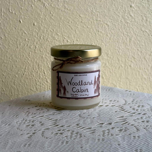 Woodland Cabin 3.4oz candle on a lace table cloth