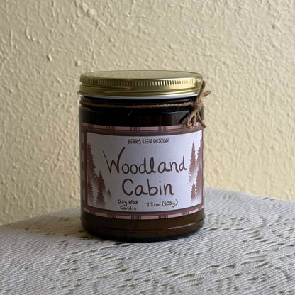 Woodland Cabin 7.2oz candle on a lace table cloth